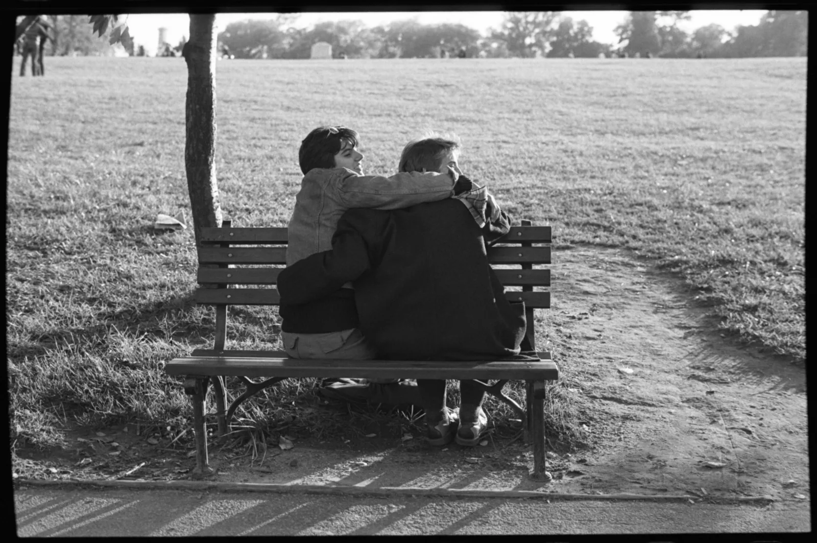 Midwest ms militante box 001 fl 007 023 Two people sit and embrace on a park bench.